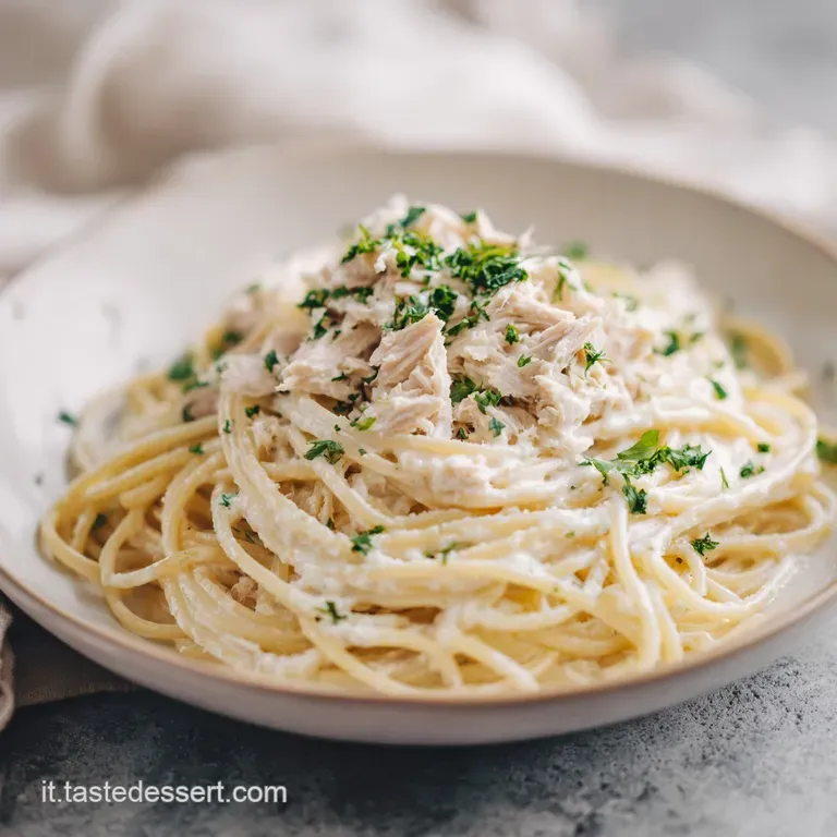 Plated spaghetti al tonno: delicate strands coated in a light sauce, topped with tuna and vibrant green parsley sprigs.